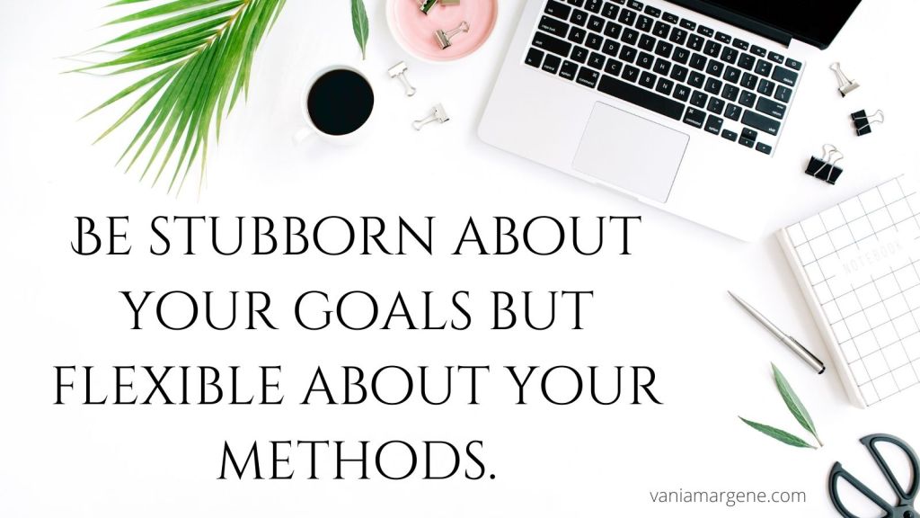desk with laptop, plant, and coffee.

be stubborn about your goals but flexible about your methods.