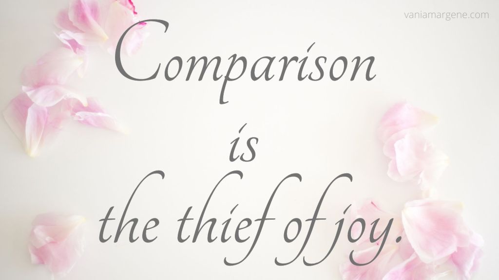 Comparison is the thief of joy. Text typed over pink and white flower petals.