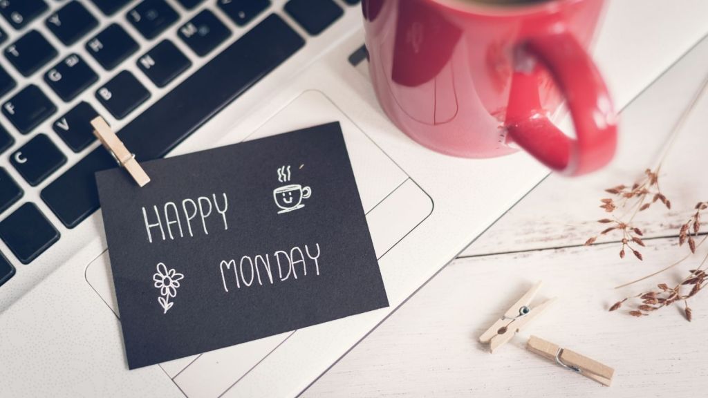 Happy Monday! laptop with red coffee mug, paperclips and scratch paper that says happy monday