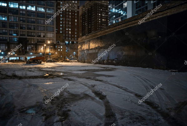 stock photo of a city street at night. snow on the ground
