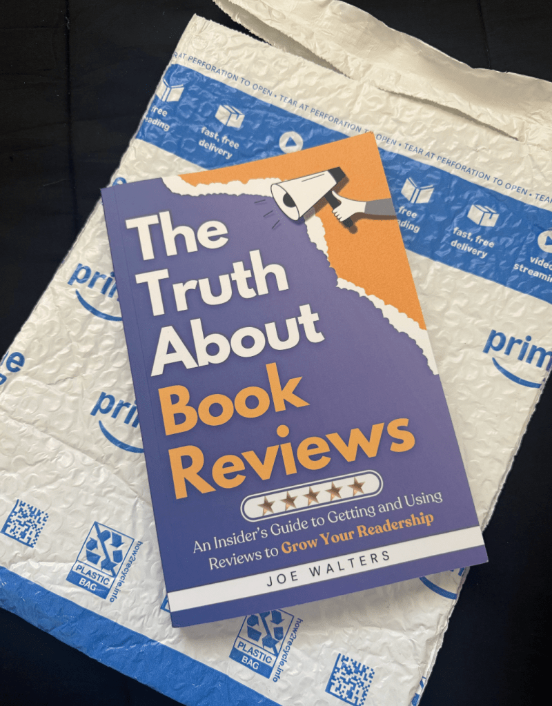 picture of the truth about book reviews book lying on the amazon bubble mailer. black background.