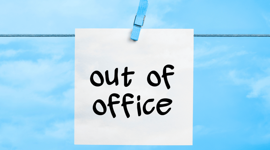 out of office sticky note that says out of office attached to a line with a blue clothes pin. blue background