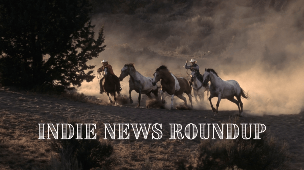 A Western-themed blog graphic showing two cowboys on horseback herding several horses across a dusty landscape. Clouds of dust rise behind the galloping horses, with trees and hills in the background. Large white Western-style lettering across the bottom reads “INDIE NEWS ROUNDUP.”